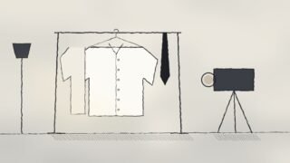 Ilustración a tinta: una camisa blanca en un perchero junto a una corbata oscura, frente a una cámara de estudio